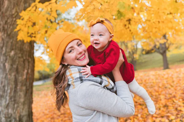 Baby daughter and her mother in the autumn season in park — Stock Photo, Image