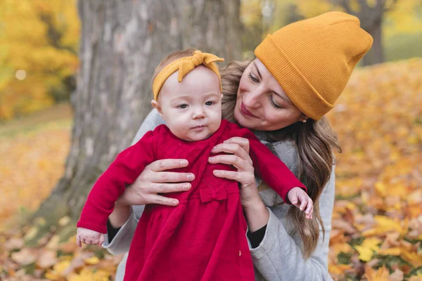 Kleine Tochter und ihre Mutter im Herbst im Park — Stockfoto