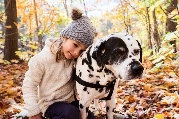 Flicka med dalmatiner hund på hösten säsong — Stockfoto