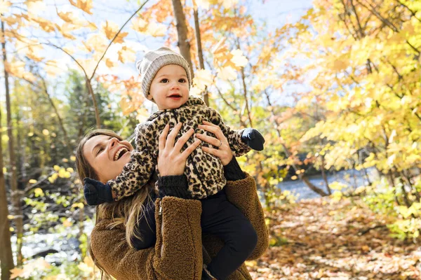 Little girl and her mother playing in the autumn park — Stock Photo, Image