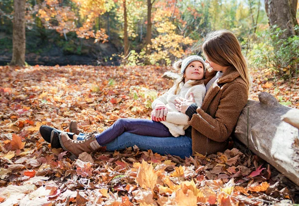 Kleines Mädchen und ihre Mutter spielen im Herbstpark — Stockfoto