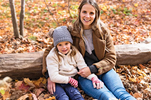 Kleines Mädchen und ihre Mutter spielen im Herbstpark — Stockfoto