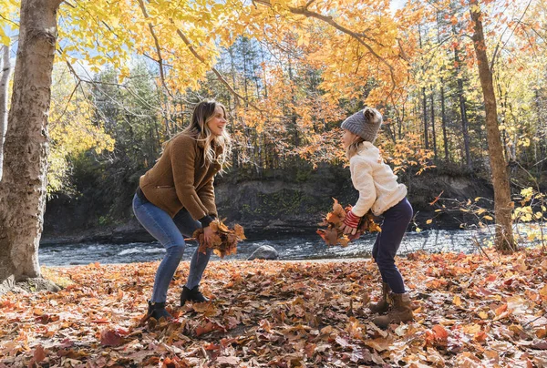 Küçük kız ve annesi sonbahar parkında yapraklarla oynuyorlar. — Stok fotoğraf
