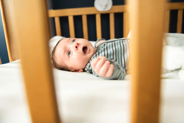 Um bebezinho deitado na cama no berçário — Fotografia de Stock