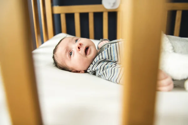 Un bebé pequeño acostado en la cama en el vivero — Foto de Stock