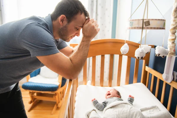 Pai cansado com bebê perturbado sofrendo com depressão pós-natal. — Fotografia de Stock