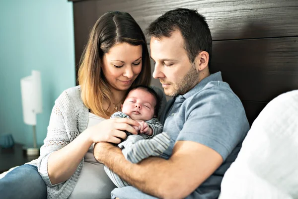 Una bella coppia con neonato sul letto. — Foto Stock