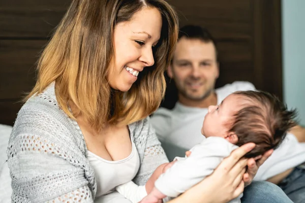 A beautiful couple with newborn Baby on bed. — Stock Photo, Image