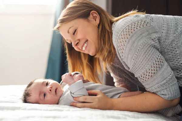 Mamá y bebé teniendo maravilloso tiempo en la cama en la mañana — Foto de Stock