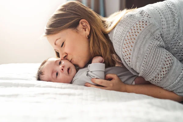 Mamá y bebé teniendo maravilloso tiempo en la cama en la mañana — Foto de Stock