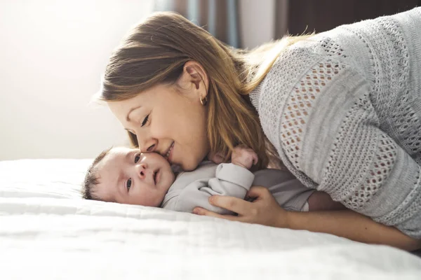 Mamá y bebé teniendo maravilloso tiempo en la cama en la mañana — Foto de Stock