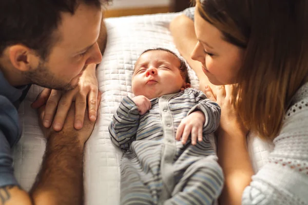 Yeni doğmuş bebeğiyle yatakta güzel bir çift. — Stok fotoğraf