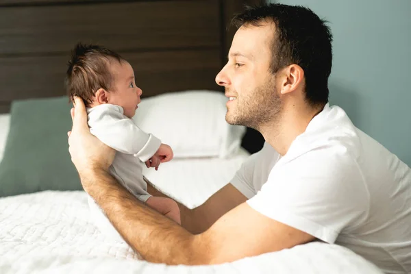 Отец и новорожденный ребенок крупным планом на кровати. — стоковое фото