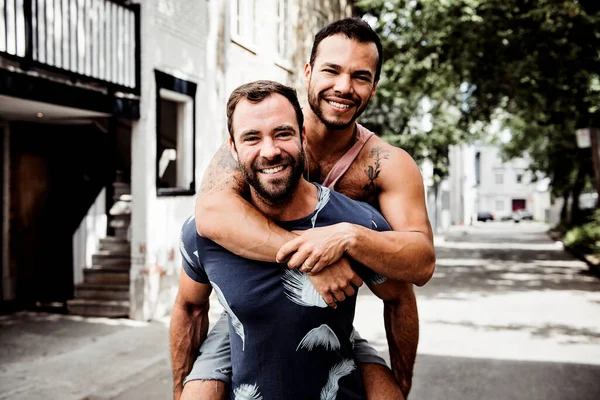 Um retrato de um feliz casal gay ao ar livre no fundo urbano — Fotografia de Stock