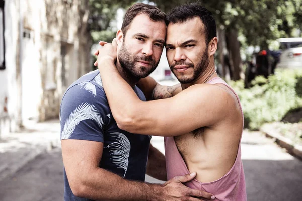 Ett porträtt av ett lyckligt homosexuellt par utomhus i urban bakgrund — Stockfoto