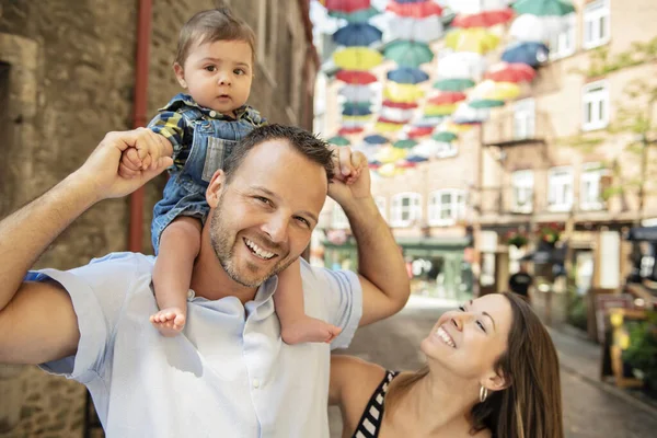 Happy family of three on the street with baby — Stock Photo, Image
