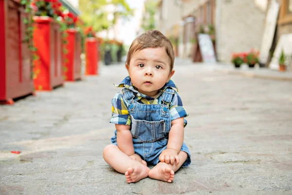 Porträtt stilig pojke sitter på sten gata — Stockfoto