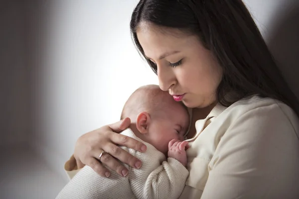 Young mother with his daughter sit on a white floor studio, trying to consoling — Stock Photo, Image