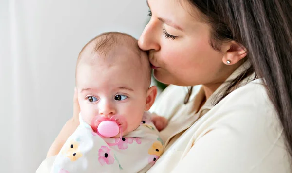 Familj mamma leker med nyfödda barn på baby rummet — Stockfoto