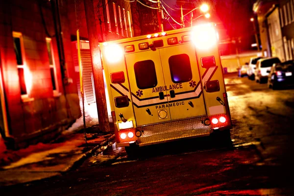 Un coche ambulancia estacionado en la calle lateral por la noche —  Fotos de Stock