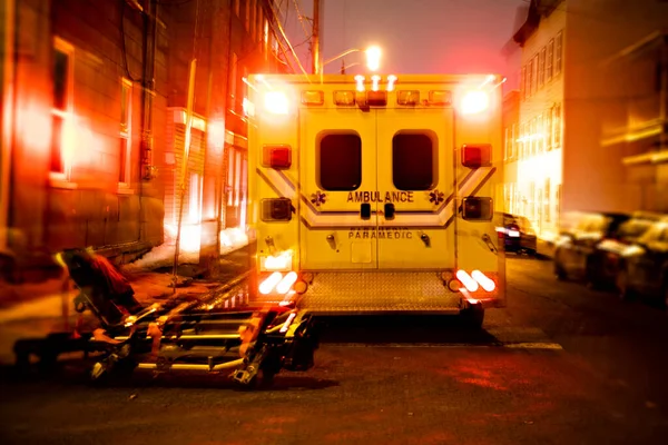 Машина скорой помощи припаркована на боковой улице ночью. — стоковое фото