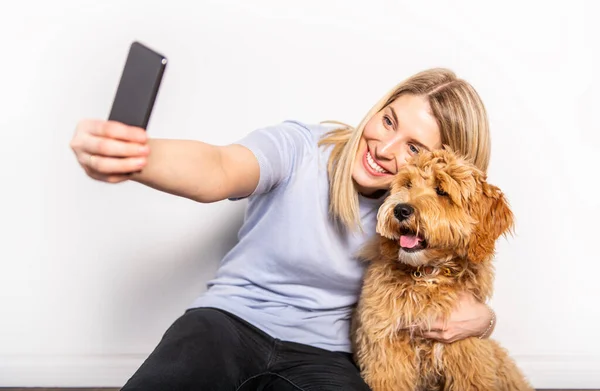 Žena s jeho Golden Labradoodle pes izolované na bílém pozadí — Stock fotografie