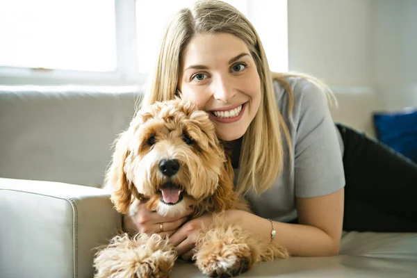 Vrouw met zijn gouden labradoodle hond thuis — Stockfoto