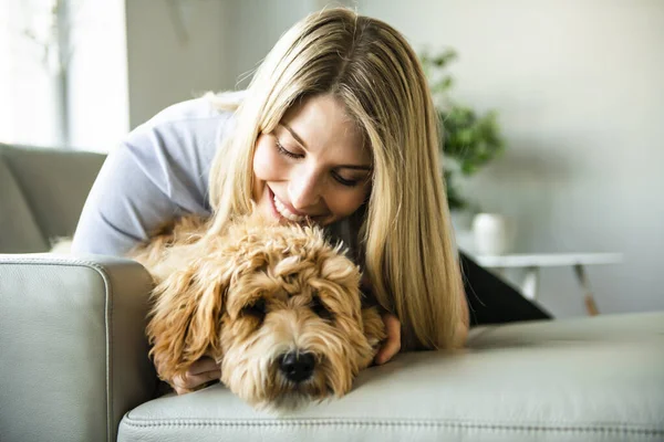Žena s jeho zlatým labradoodle psem doma — Stock fotografie