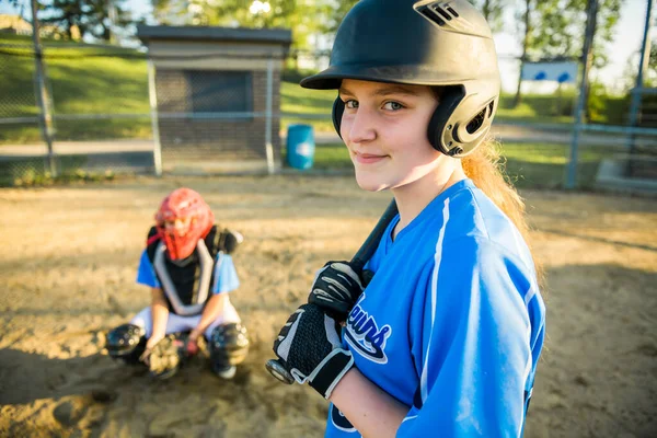 女の子野球選手とともにバットオンザ遊び場 — ストック写真
