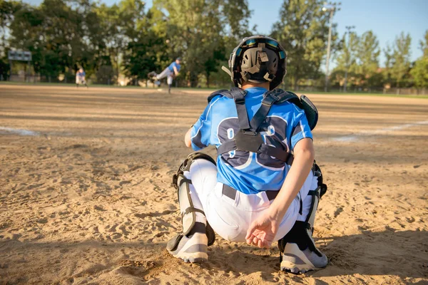 En barn baseball catcher spelare bakifrån står på lekplatsen — Stockfoto