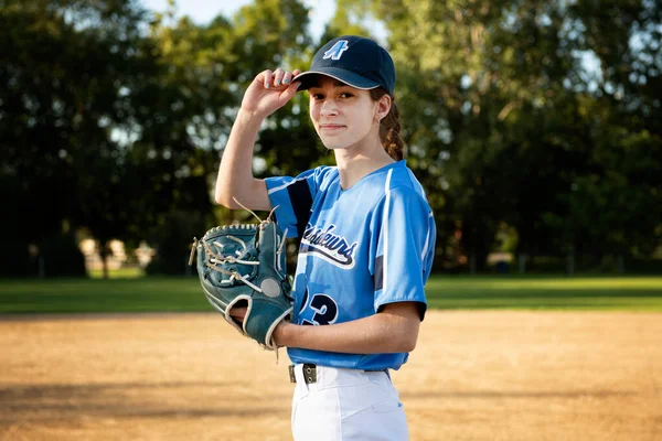 En barnflicka basebollspelare står på lekplatsen — Stockfoto