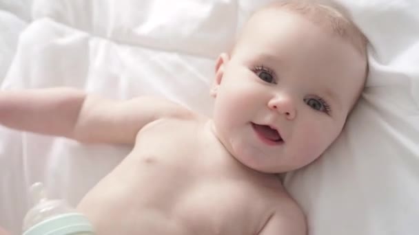 Baby girl in white bedding at home look nice — Stock Video