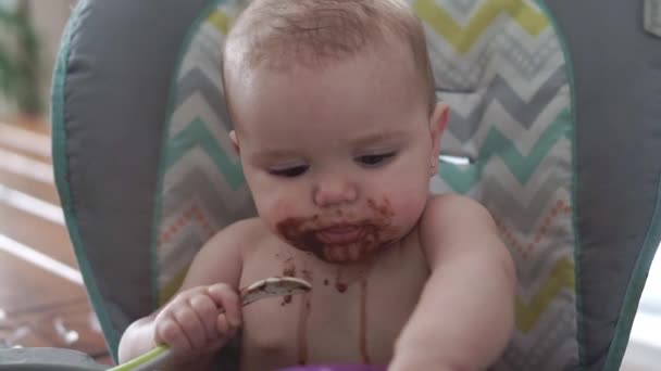 Portrét Happy Young Baby dívka na vysoké židli jíst čokoládu — Stock video