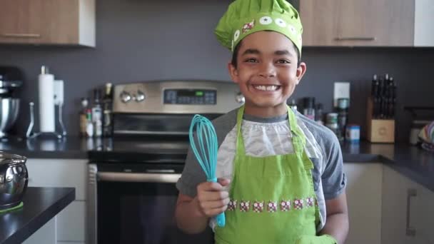Mutfakta şef şapkası takan küçük tatlı bir çocuk. — Stok video