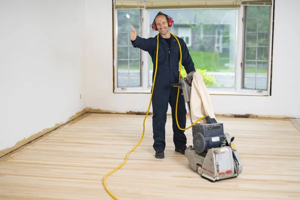 Un piso de madera de lijado con la máquina de pulir. — Foto de Stock