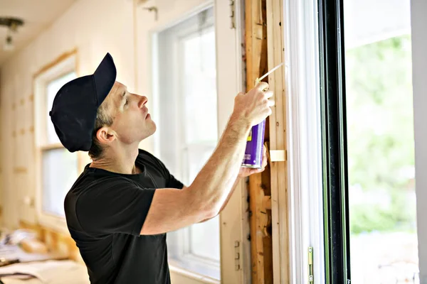 A handsome young man installing Double Sliding Patio Door in a new house construction site — Stock Photo, Image