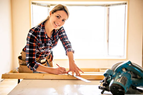 Uma mulher trabalhadora na renovação da sala de trabalho do carpinteiro — Fotografia de Stock