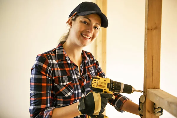 Uma mulher trabalhadora na renovação da sala de trabalho do carpinteiro — Fotografia de Stock