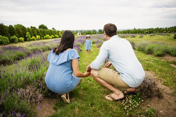 Feliz familia madre, padre e hija divirtiéndose en el campo de la lavanda —  Fotos de Stock