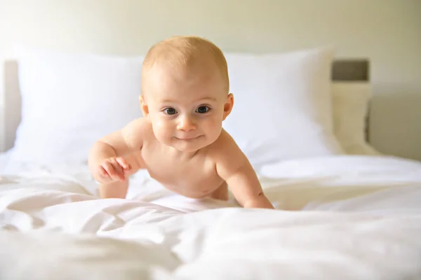 Mignon bébé fille heureuse dans la couche sur le lit — Photo