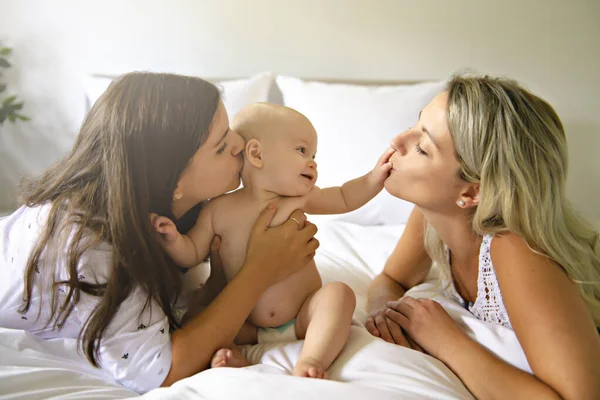 Две лесбиянки мать и ребенок в постели веселятся — стоковое фото