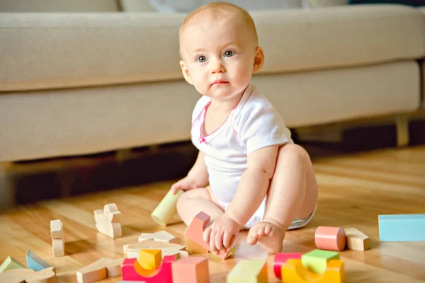 Un bébé drôle rampant à l'intérieur à la maison jouer avec le bloc — Photo