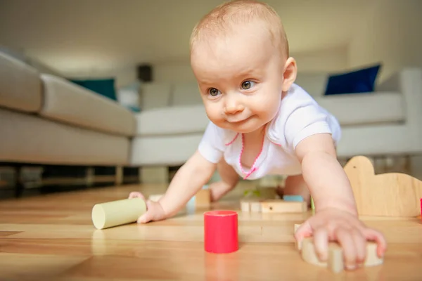 Un bebé divertido gateando dentro de casa jugar con el bloque — Foto de Stock