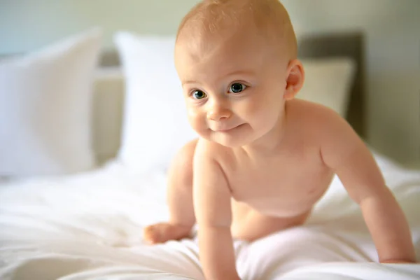 Mignon bébé fille heureuse dans la couche sur le lit — Photo