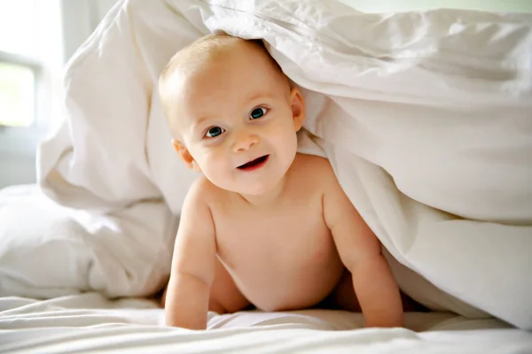 Mignon bébé fille heureuse dans la couche sur le lit — Photo