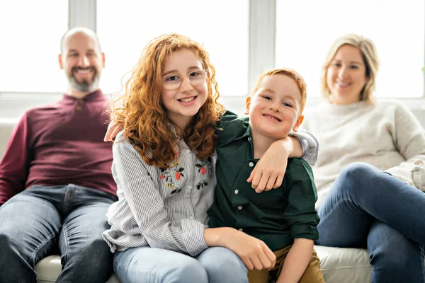 Una hermosa familia feliz divirtiéndose en el sofá en casa — Foto de Stock