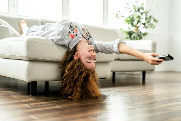 Positivo rossa adolescente sdraiato su un divano. — Foto Stock