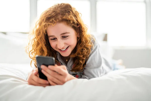 Una rossa giovane ragazza adolescente sul suo letto — Foto Stock