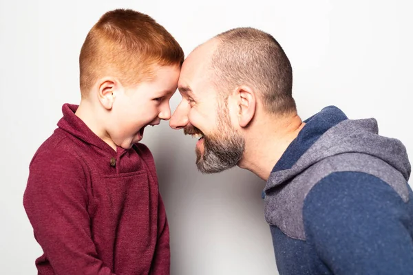 Alegre pelirroja padre e hijo y sonriendo a cámara aislada en blanco — Foto de Stock