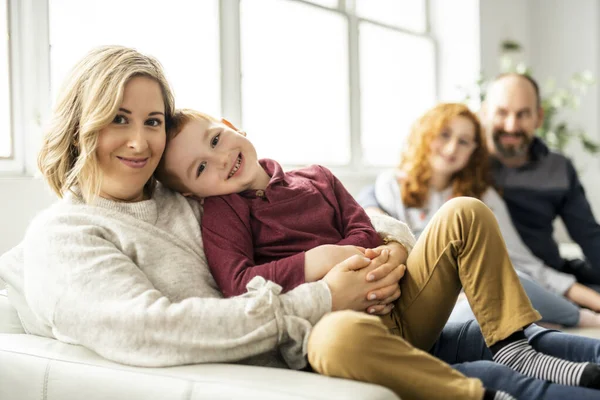 Una hermosa familia feliz divirtiéndose en el sofá en casa — Foto de Stock